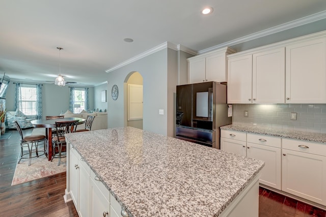 kitchen featuring open floor plan, dark wood-type flooring, smart refrigerator, arched walkways, and crown molding
