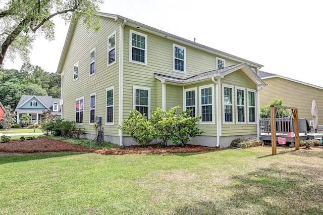 rear view of property with a wooden deck and a yard