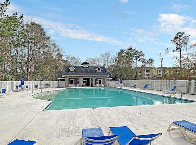 community pool featuring fence and a patio