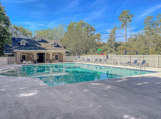 community pool with fence and a patio