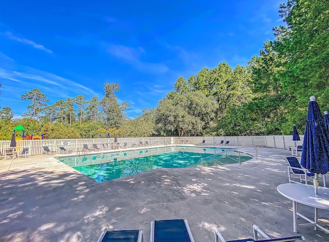 community pool featuring fence and a patio area