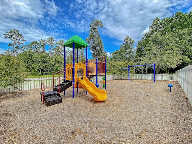 communal playground with fence and view of scattered trees