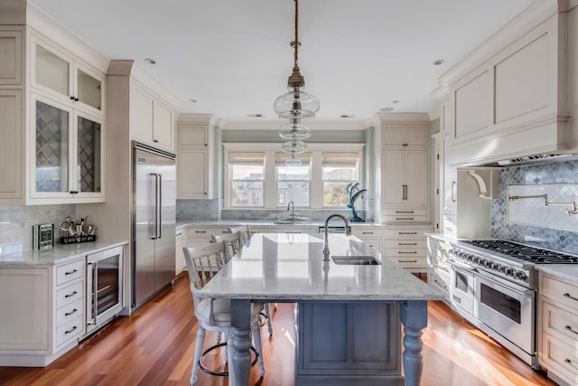 4001 Palm Blvd, Isle Of Palms, SC 29451 - kitchen with beverage cooler, premium appliances, a sink, decorative backsplash, and a kitchen bar