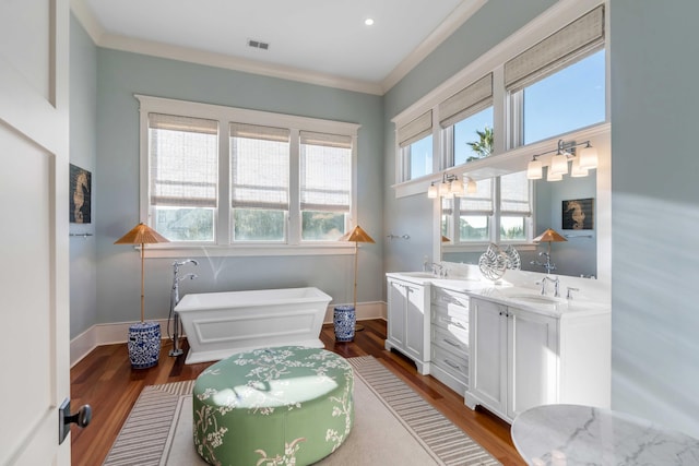 4001 Palm Blvd, Isle Of Palms, SC 29451 - bathroom featuring a freestanding bath, double vanity, wood finished floors, crown molding, and baseboards