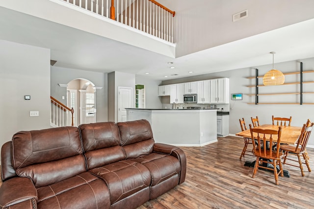 living room featuring hardwood / wood-style flooring and a high ceiling