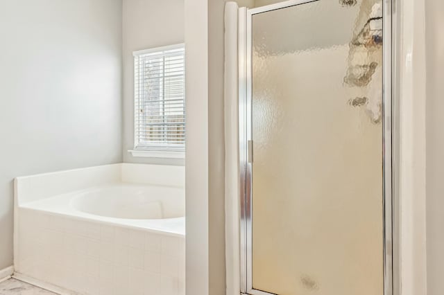 bathroom featuring shower with separate bathtub