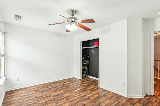 unfurnished bedroom with dark wood-type flooring, a closet, and ceiling fan