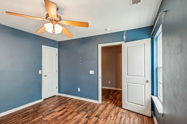 unfurnished bedroom featuring dark wood-type flooring and ceiling fan