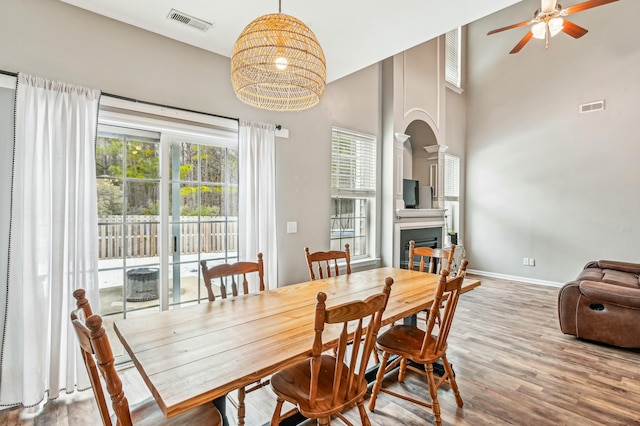 dining room with ceiling fan, hardwood / wood-style floors, and a high ceiling