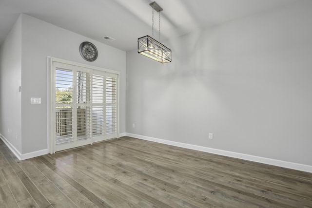 unfurnished dining area featuring hardwood / wood-style flooring and a notable chandelier