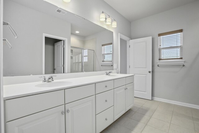 bathroom featuring tile patterned flooring, a shower with shower door, and vanity