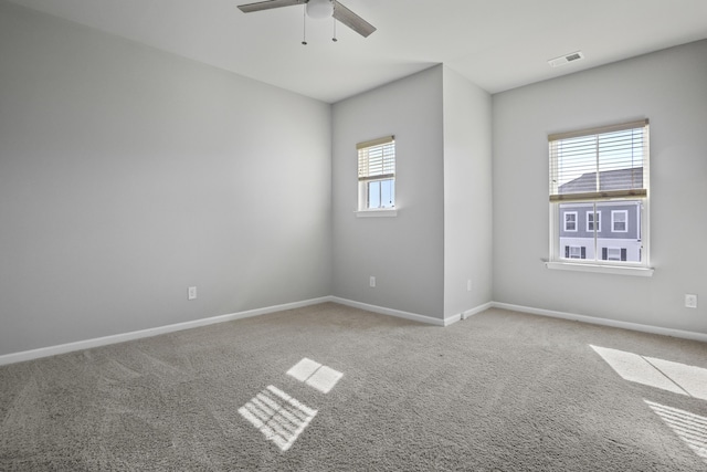 spare room featuring light carpet, a healthy amount of sunlight, and ceiling fan