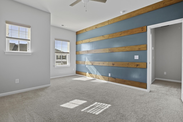 empty room featuring ceiling fan and light colored carpet