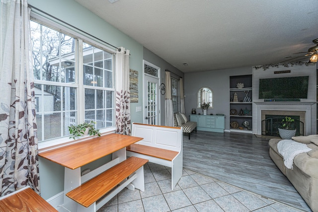 interior space featuring ceiling fan, tile patterned flooring, a wealth of natural light, and a textured ceiling