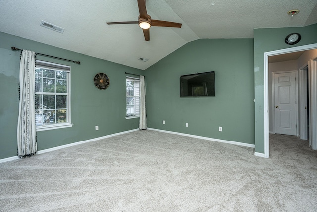 interior space with visible vents, baseboards, lofted ceiling, carpet floors, and a textured ceiling