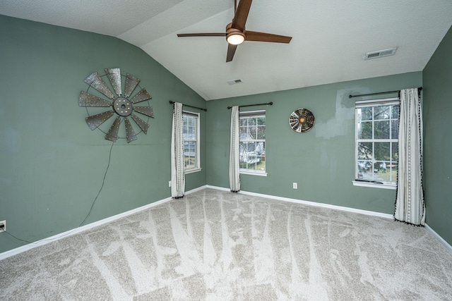 unfurnished room with visible vents, carpet, ceiling fan, and vaulted ceiling