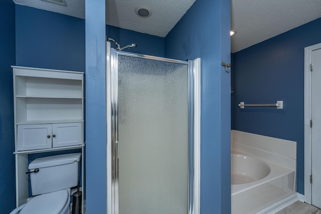 full bath featuring a textured ceiling, a bath, a shower stall, and toilet