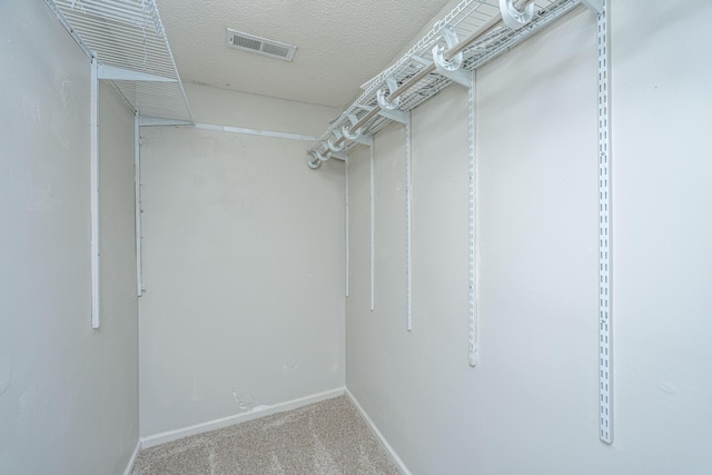 walk in closet featuring visible vents and carpet