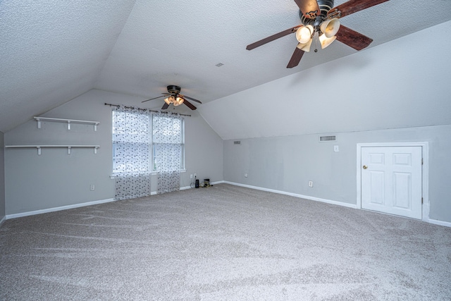 additional living space with a textured ceiling, carpet flooring, visible vents, and ceiling fan