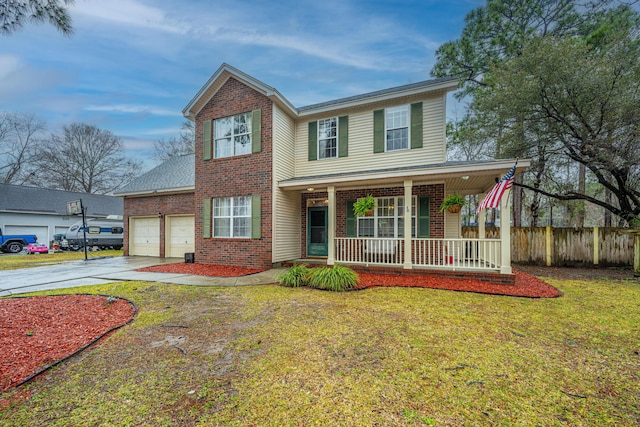 traditional home with a front yard, fence, driveway, covered porch, and brick siding