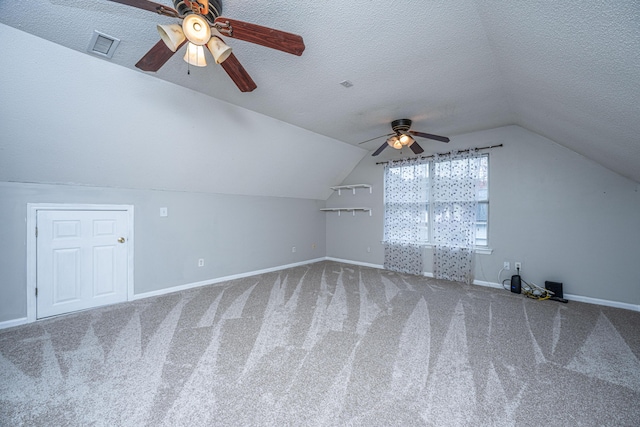 bonus room with a textured ceiling, carpet, a ceiling fan, and vaulted ceiling