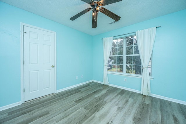 unfurnished room with ceiling fan, baseboards, and wood finished floors