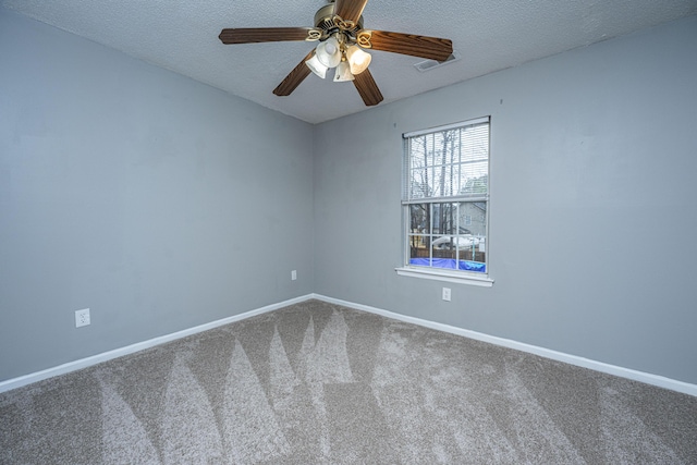 spare room with baseboards, ceiling fan, a textured ceiling, and carpet