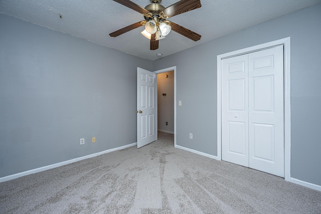 unfurnished bedroom with a closet, baseboards, a textured ceiling, and carpet floors