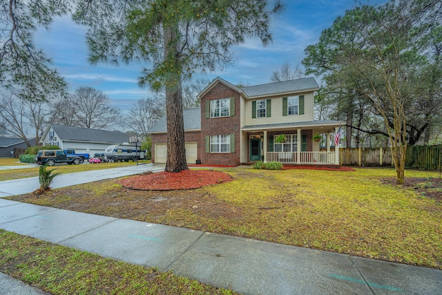 view of front of house featuring a front yard, fence, driveway, a porch, and brick siding