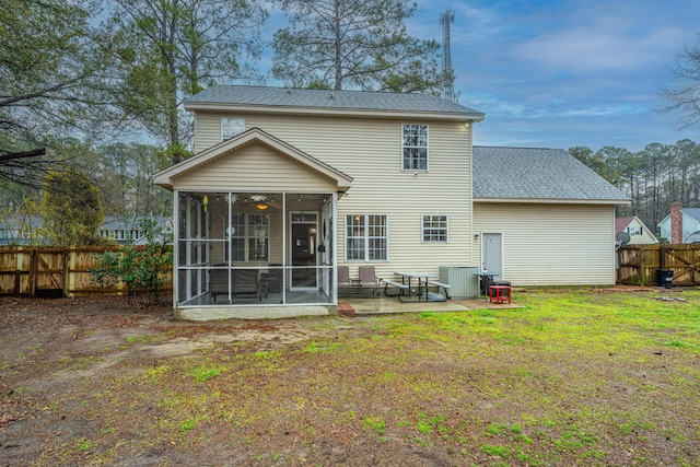 rear view of house featuring a patio, fence, a yard, a sunroom, and a shingled roof