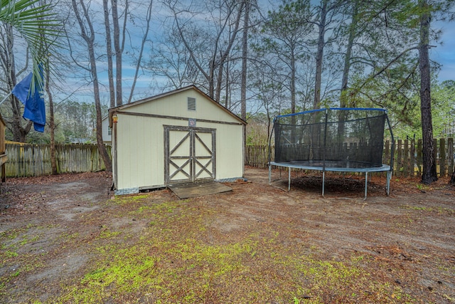 view of shed featuring a trampoline and a fenced backyard