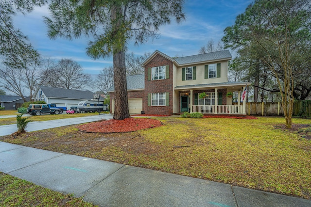 view of front facade with a front yard, covered porch, concrete driveway, a garage, and brick siding