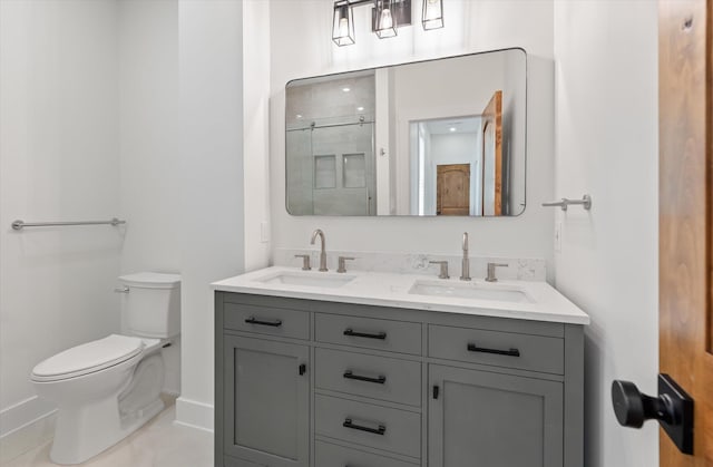 bathroom with vanity, tile patterned floors, toilet, and walk in shower