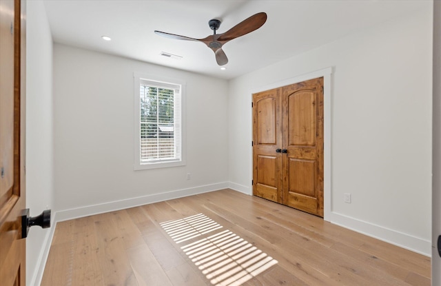 unfurnished bedroom featuring light hardwood / wood-style flooring, a closet, and ceiling fan