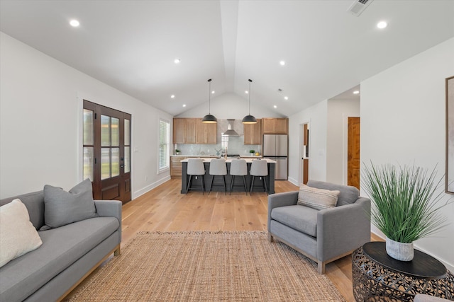 living room with lofted ceiling and light hardwood / wood-style flooring