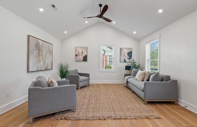 living room with light hardwood / wood-style floors, a healthy amount of sunlight, high vaulted ceiling, and ceiling fan