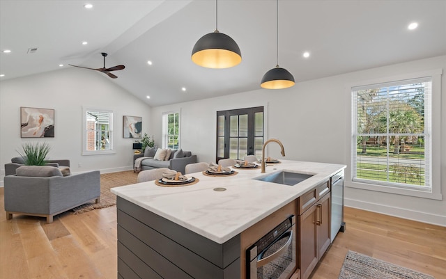 kitchen with sink, light hardwood / wood-style floors, hanging light fixtures, and a healthy amount of sunlight