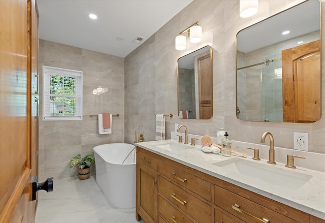 bathroom featuring vanity, tile walls, and shower with separate bathtub