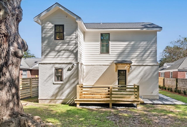 back of property featuring a yard and a deck