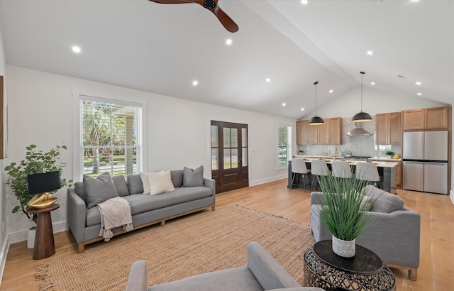 living room with lofted ceiling, light wood-type flooring, and ceiling fan