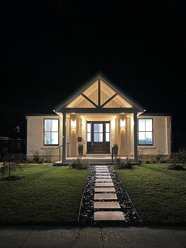 view of front of property featuring covered porch and a yard