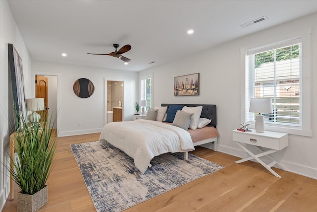 bedroom with light hardwood / wood-style flooring, ensuite bath, and ceiling fan