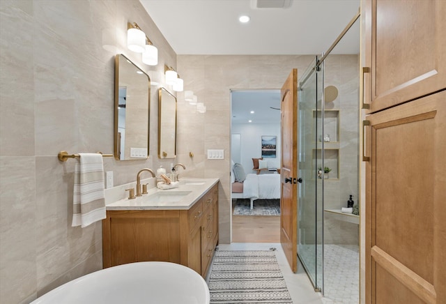 bathroom featuring vanity, tile walls, a shower with shower door, and tile patterned flooring