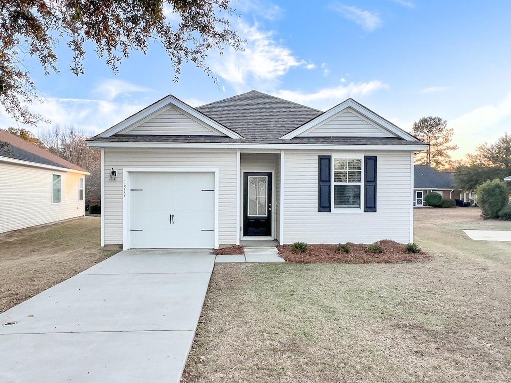 ranch-style house featuring a front yard and a garage