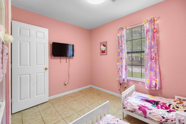 bedroom with baseboards and light tile patterned floors