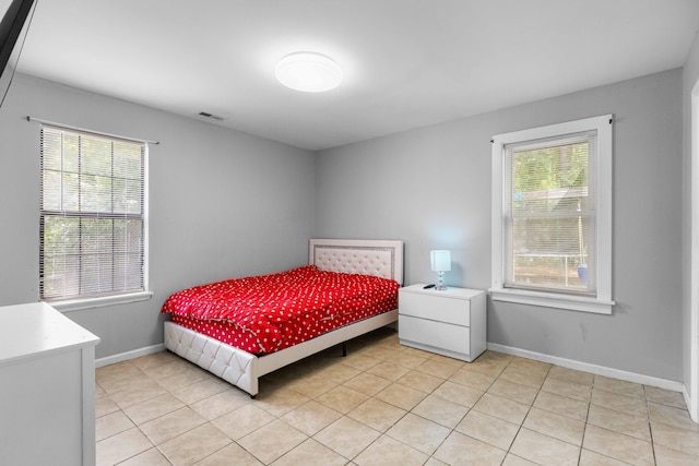 bedroom featuring baseboards, visible vents, and light tile patterned floors
