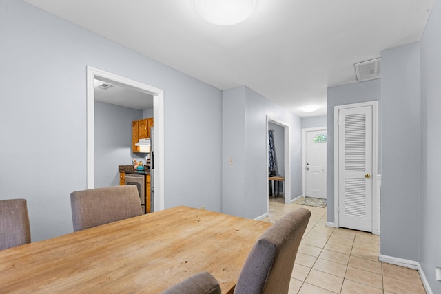 dining area with light tile patterned flooring, visible vents, and baseboards