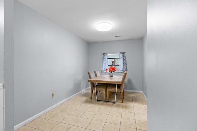 dining space featuring baseboards, visible vents, and light tile patterned flooring