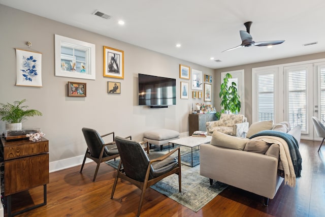 living room featuring ceiling fan and dark hardwood / wood-style floors