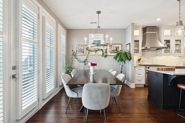 dining area with dark hardwood / wood-style flooring and a notable chandelier